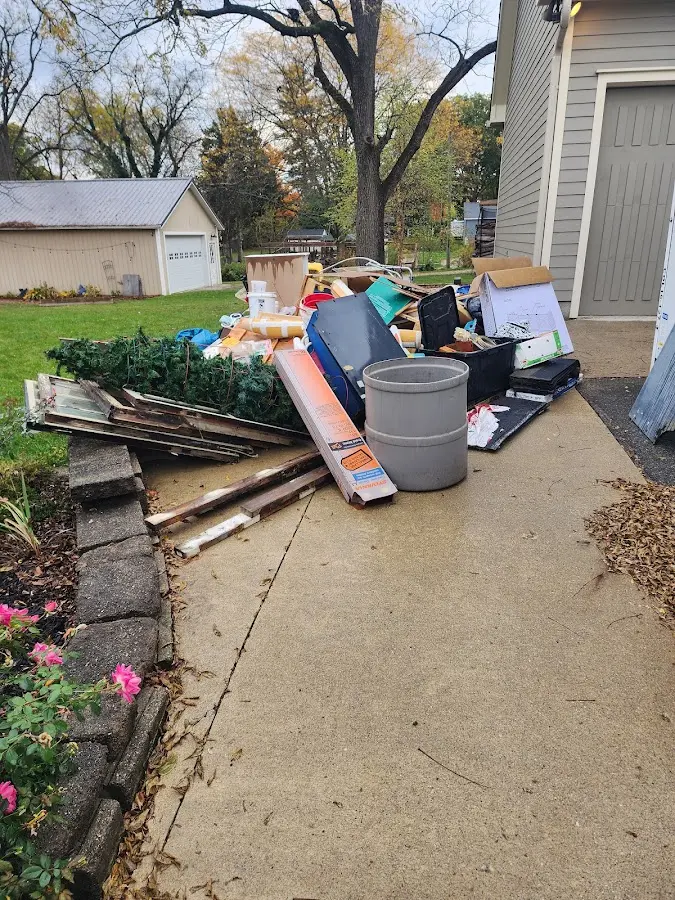 Dumpster being loaded with debris for Estate Cleanout Dumpster Rental in Lansing